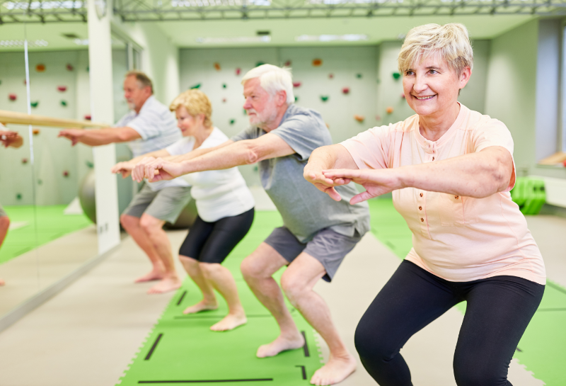 elderly group doing squats to strengthen legs
